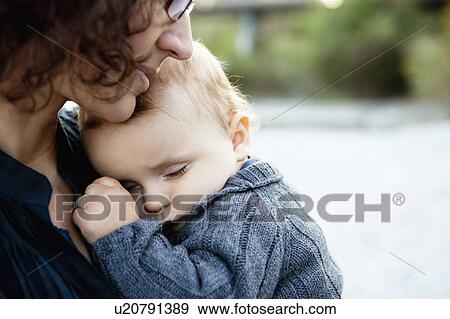 Stock Photo - Mother holding sleeping baby. Fotosearch