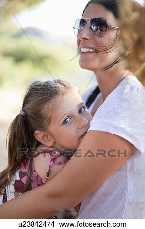 Mother hugging daughter outdoors View Large Photo Image Picture - Mother hugging daughter outdoors. Fotosearch