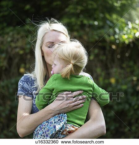 Stock Image - Mother kissing baby daughter . Fotosearch