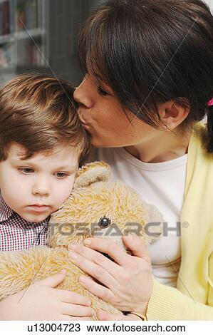 Mother kissing son in living room View Large Photo Image Stock Image - Mother kissing son in living room. Fotosearch