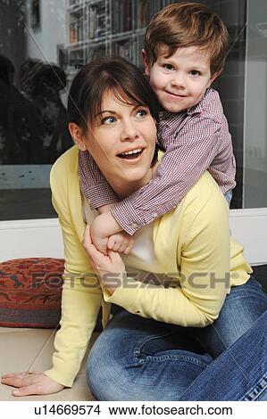 Mother playing with son in living room View Large Photo Image Picture - Mother playing with son in living room. Fotosearch