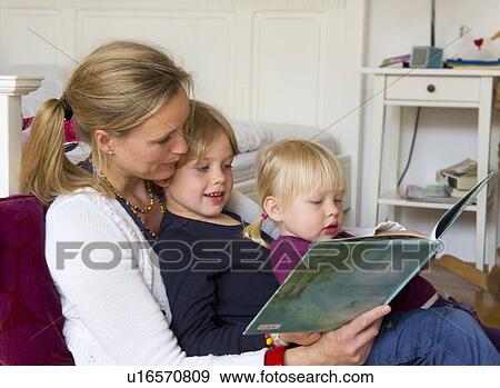 Mother reading to children in bedroom View Large Photo Image Stock Photo - Mother reading to children in bedroom. Fotosearch