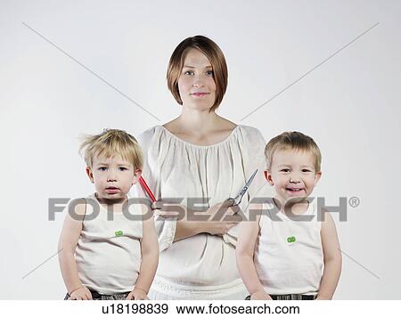Stock Photo - Mother standing with twin boys. Fotosearch