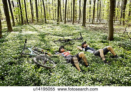 Mountain bikers relaxing in forest View Large Photo Image Stock Photography - Mountain bikers relaxing in forest. Fotosearch