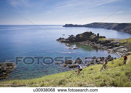 Mountain bikers riding on coastline View Large Photo Image Stock Photo - Mountain bikers riding on coastline. Fotosearch