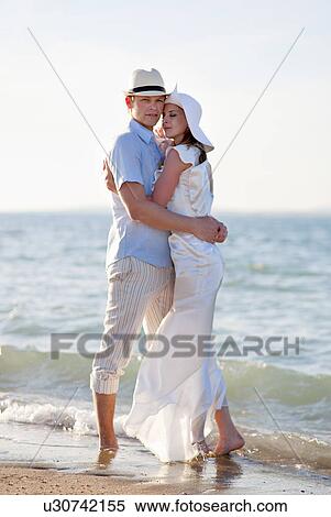 Stock Photography - Newlywed couple embracing on beach. Fotosearch