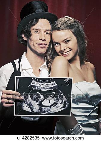 Newlywed couple holding sonogram View Large Photo Image Stock Photography - Newlywed couple holding sonogram. Fotosearch