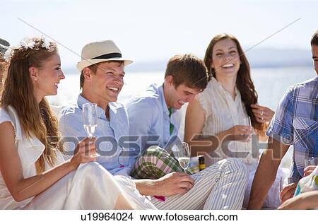 Newlywed couple laughing with friends View Large Photo Image Picture - Newlywed couple laughing with friends. Fotosearch