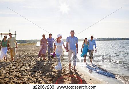 Stock Image - Newlywed couple on beach with friends. Fotosearch
