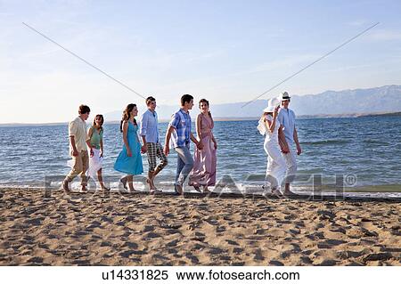 Stock Photography - Newlywed couple on beach with friends. Fotosearch