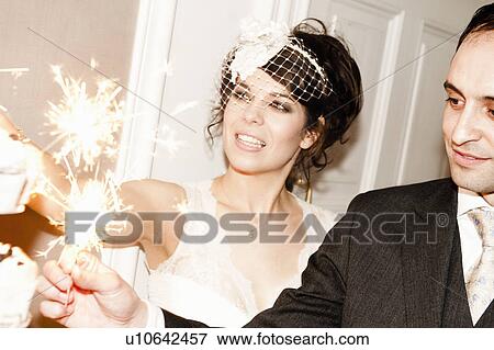 Newlywed couple with sparklers on cake View Large Photo Image Stock Photo - Newlywed couple with sparklers on cake. Fotosearch