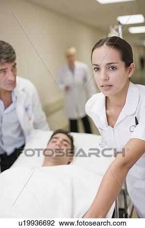 Stock Image - Nurse rushing patient down hallway. Fotosearch