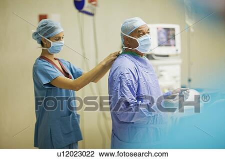 Nurse tying mask on surgeon View Large Photo Image Stock Image - Nurse tying mask on surgeon. Fotosearch