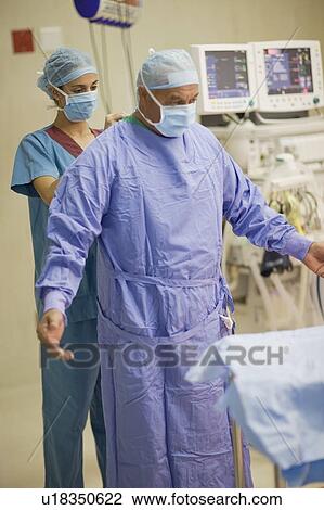 Nurse tying scrubs on surgeon View Large Photo Image Stock Image - Nurse tying scrubs on surgeon. Fotosearch