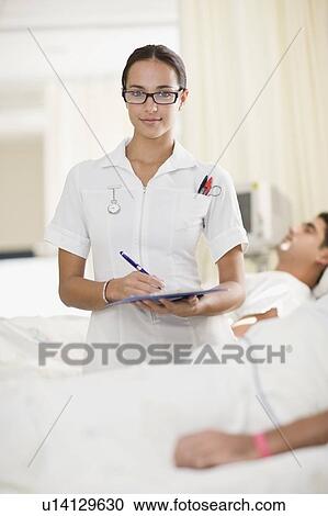 Nurse with clipboard in hospital room View Large Photo Image Stock Image - Nurse with clipboard in hospital room. Fotosearch