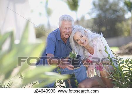 Stock Image - Older couple gardening together. Fotosearch