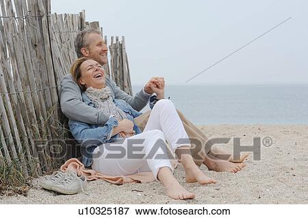 Stock Photo - Older couple hugging on beach. Fotosearch