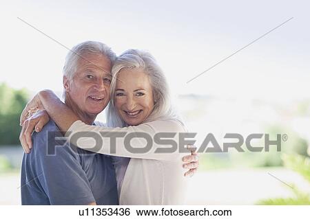 Older couple hugging outdoors View Large Photo Image Stock Photograph - Older couple hugging outdoors. Fotosearch