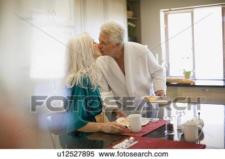 Stock Photography - Older couple in bathrobes at breakfast. Fotosearch