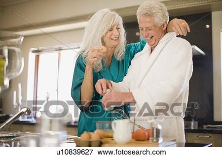 Stock Photo - Older couple in bathrobes cooking. Fotosearch