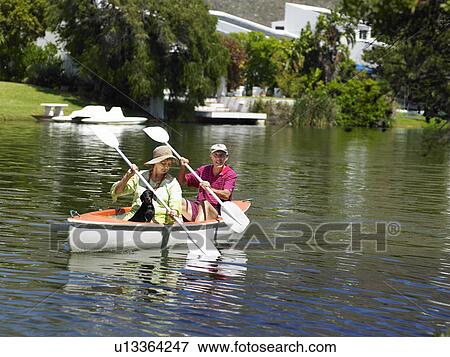 Stock Photo - Older couple rowing canoe on lake. Fotosearch