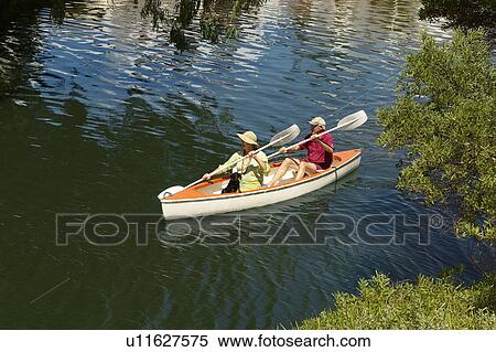 Stock Photography - Older couple rowing canoe on lake. Fotosearch