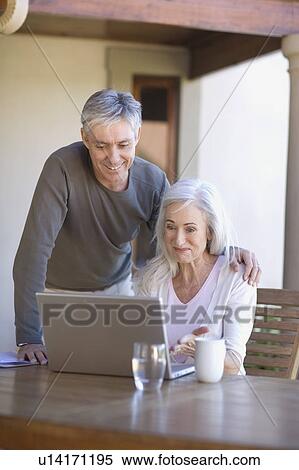 Older couple using laptop together View Large Photo Image Stock Photography - Older couple using laptop together. Fotosearch