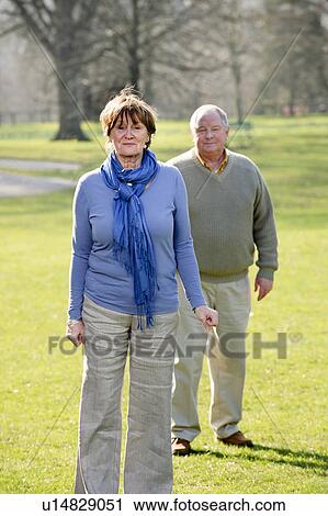 Older couple walking in park View Large Photo Image Stock Image - Older couple walking in park. Fotosearch