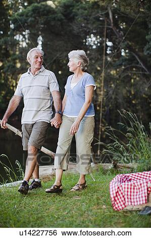 Older couple walking together outdoors View Large Photo Image Stock Photograph - Older couple walking together outdoors. Fotosearch