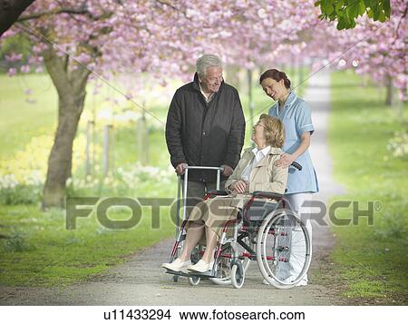 Older couple with caretaker in park View Large Photo Image Picture - Older couple with caretaker in park. Fotosearch