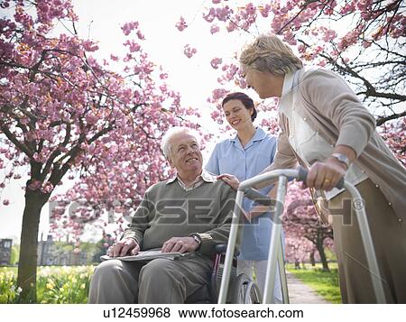 Older couple with caretaker in park View Large Photo Image Stock Photo - Older couple with caretaker in park. Fotosearch