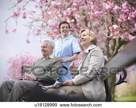 Older couple with caretaker in park View Large Photo Image Stock Photo - Older couple with caretaker in park. Fotosearch