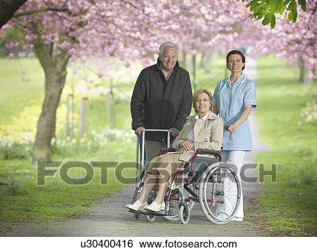 Older couple with caretaker in park View Large Photo Image Stock Photograph - Older couple with caretaker in park. Fotosearch