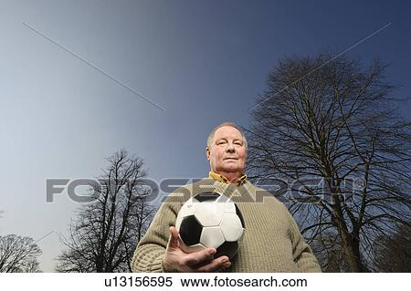 Older man carrying soccer ball View Large Photo Image Stock Photography - Older man carrying soccer ball. Fotosearch