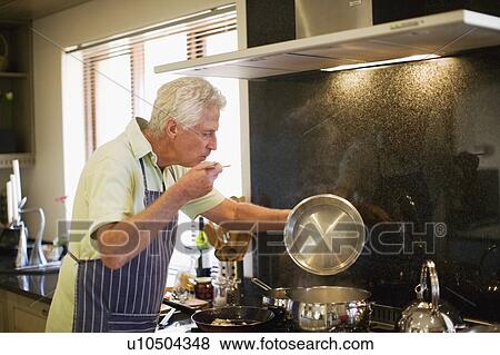 Older man cooking in kitchen View Large Photo Image Stock Photo - Older man cooking in kitchen. Fotosearch