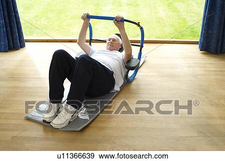 Older man doing sit-ups indoors View Large Photo Image Stock Photo - Older man doing sit-ups indoors. Fotosearch