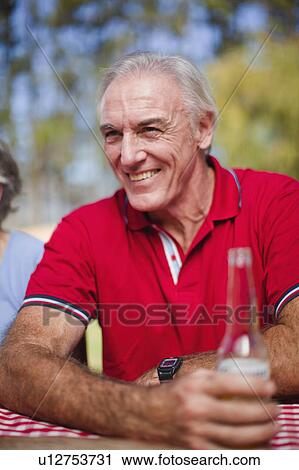 Older man drinking at picnic table View Large Photo Image Stock Image - Older man drinking at picnic table. Fotosearch