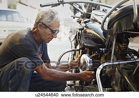 Older man examining his motorcycle View Large Photo Image Stock Image - Older man examining his motorcycle. Fotosearch