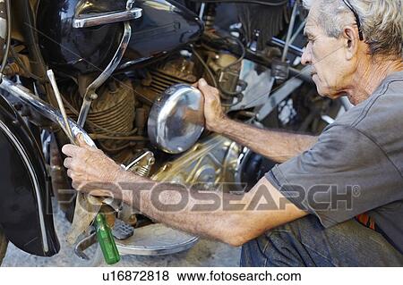 Older man examining his motorcycle View Large Photo Image Stock Photo - Older man examining his motorcycle. Fotosearch
