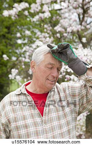Picture - Older man wiping his brow. Fotosearch