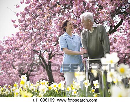 Older man with caretaker in park View Large Photo Image Stock Photo - Older man with caretaker in park. Fotosearch