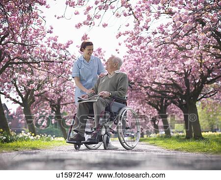 Stock Photo - Older man with caretaker in park. Fotosearch