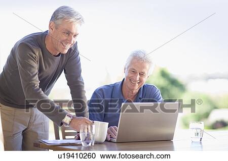 Older men using laptop together View Large Photo Image Stock Image - Older men using laptop together. Fotosearch