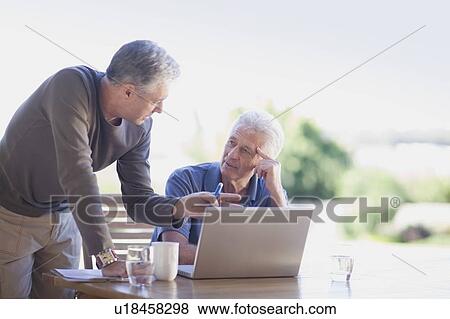 Older men using laptop together View Large Photo Image Stock Photo - Older men using laptop together. Fotosearch