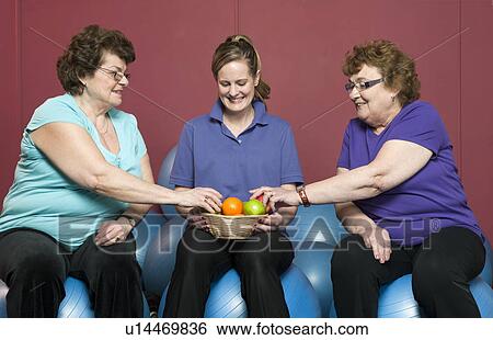 Stock Photograph - Older woman having fruit in gym. Fotosearch