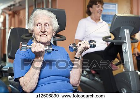 Older woman lifting weights in gym View Large Photo Image Stock Image - Older woman lifting weights in gym. Fotosearch