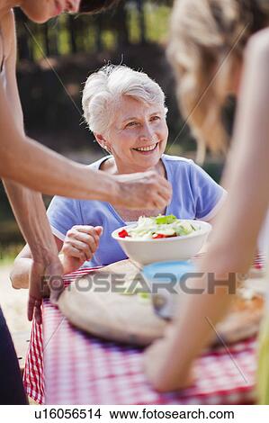 Older woman sitting at picnic table View Large Photo Image Picture - Older woman sitting at picnic table. Fotosearch