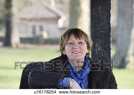 Picture - Older woman sitting on park bench. Fotosearch
