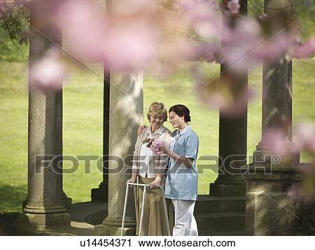 Older woman with caretaker in park View Large Photo Image Stock Image - Older woman with caretaker in park. Fotosearch