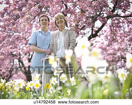 Older woman with caretaker in park View Large Photo Image Stock Photo - Older woman with caretaker in park. Fotosearch